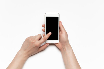 Close up of human hands using smartphone isolated on white background. Top view. Copyspace, blank screen. Surfing, online shopping, scrolling, betting, working. Education and business concept.