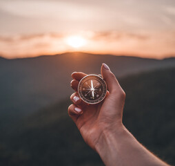 Woman hand with magnetic compass in summer mountains at sunrise, pov. - 360169176
