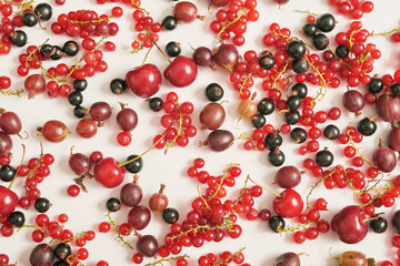 Fruit pattern of colorful fresh berries on white background. Top view. Flat lay. Summer Organic Berry Cherry, Currant, Gooseberry. Agriculture, Gardening, Harvest Concept. Vitamins, Healthy Diet.