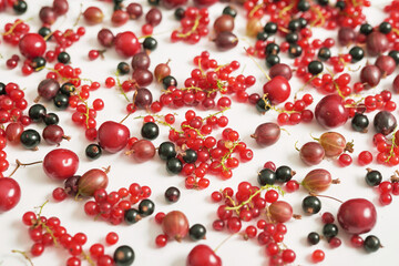 Fruit pattern of colorful fresh berries on white background. Top view. Flat lay. Summer Organic Berry Cherry, Currant, Gooseberry. Agriculture, Gardening, Harvest Concept. Vitamins, Healthy Diet.