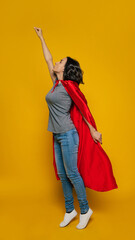 I take off! A young girl, turned sideways, pretending she is a superhero, standing in a classic...