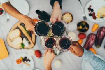 Top view shot of group of people toasting with wine glasses, Summer holiday party, Celebration Vacation People, Best friends celebrating at birthday party, Closeup of hands cheering with red wine
