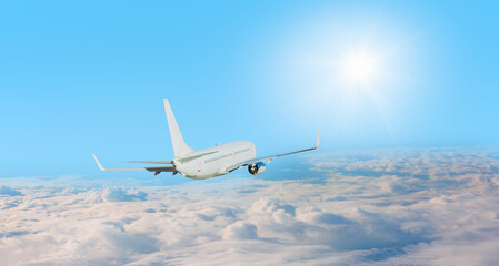 Fototapeta na wymiar White passenger airplane in the clouds with sunrays - Travel by air transport