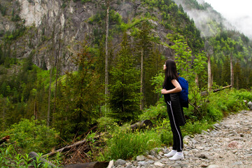 Girl travels to the mountains. Hiking. High mountains in summer on a rainy day. Тatras.