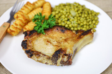 côte de porc, petits ois et pommes de terre