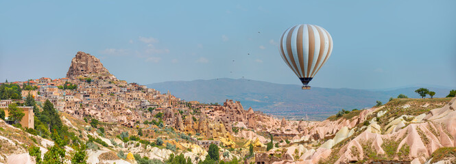Fototapeta na wymiar Hot air balloon flying over spectacular Cappadocia - Pigeon Valley with Uchisar castle - Cappadocia Turkey