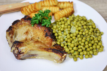 côte de porc, petits ois et pommes de terre