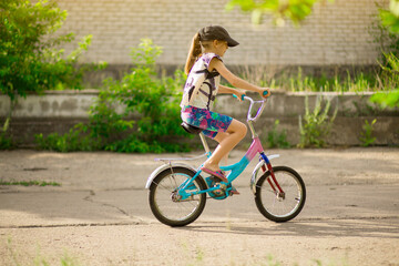 Naklejka na ściany i meble Young little girl learning to ride bike in park
