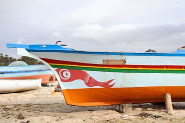 Fototapeta premium Hammamet, Tunisia- February 07, 2009: Tunisian Fishing boats on the beach with traditional colors.