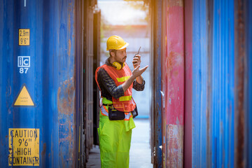 A dock worker under discussion about dock container shipping warehouse working, he wearing safety...