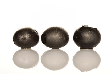 Pickled spicy black olives, close-up, on a white background.
