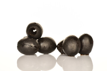 Pickled spicy black olives, close-up, on a white background.