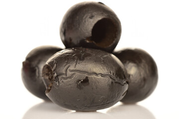 Pickled spicy black olives, close-up, on a white background.