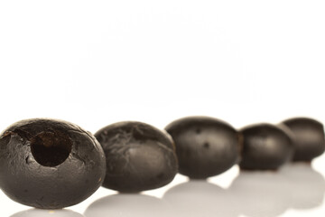 Pickled spicy black olives, close-up, on a white background.
