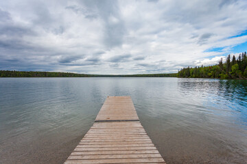 Fototapeta premium Drewniany dok rozciągający się do Clear Lake w Wasagaming, Manitoba w pochmurny dzień