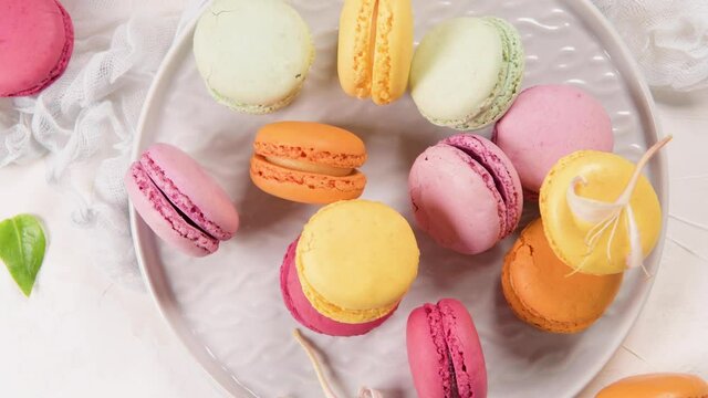 A french sweet delicacy, macaroons variety closeup. Color fresh macaroons on wooden background.