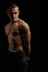 Fototapeta na wymiar View of a muscled man on a black background in artistic, fitness and bodybuilding poses.