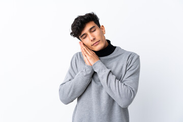 Young Argentinian man over isolated white background making sleep gesture in dorable expression