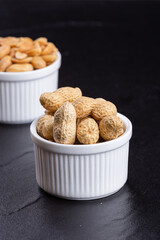 Dried peanuts on black stone background