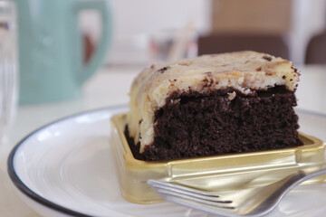 Chocolate brownies on a white plate in a coffee shop.