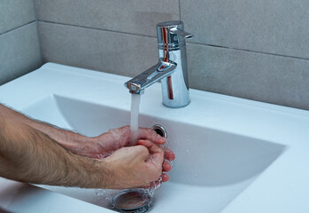 Responsible guy preventing spread virus infection, sanitizing hands regularly.