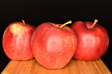 Red ripe apples, close-up, on a black background.