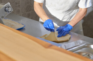 chef cooking in an open kitchen Vertuta or placinta with cottage cheese and cheese . Traditional Moldovan, Romanian or Balkan pie or cake