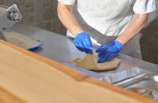 chef cooking in an open kitchen Vertuta or placinta with cottage cheese and cheese . Traditional Moldovan, Romanian or Balkan pie or cake