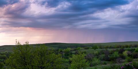 Panorama of the Don steppes in spring, in the distance it is raining, beautiful sunset sky