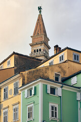 Fototapeta na wymiar The colourful houses in Piran backdropped by a bell tower.