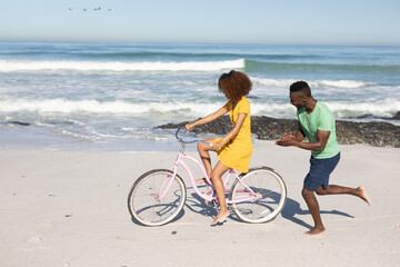 Obraz premium Mixed race couple having fun on the beach