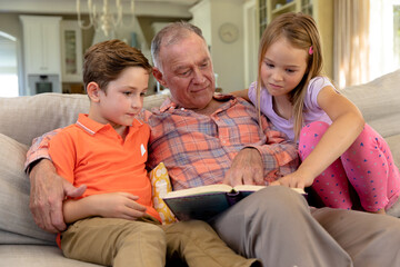 Obraz premium Grandfather and grandchildren at home in the living room