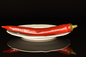 Red chili peppers, close-up, on a black background.