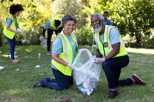 Senior mixed race couple collecting garbage