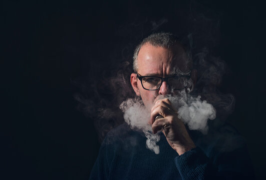 studio portrait of a man with vaporiser and glasses