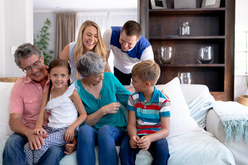 Portrait of a three generation Caucasian family  sitting on a couch at home