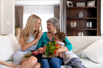 Senior Caucasian woman spending time with her daughter and her granddaughter at home