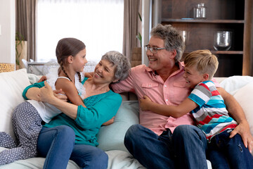 Caucasian girl and boy spending time together with their grandparents.
