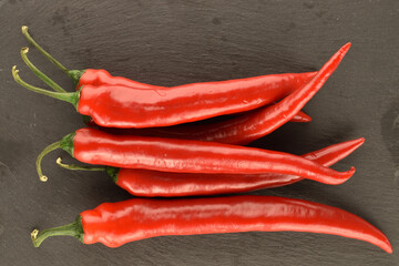 Red chili peppers, close-up, on a serving plate of slate.