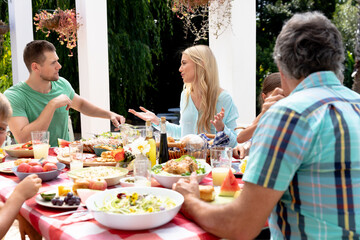 Caucasian family sitting at table during a family lunch in the garden