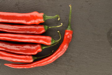Red chili peppers, close-up, on a serving plate of slate.