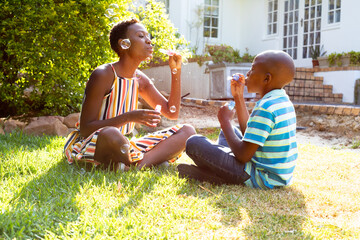 African American woman and her son, spending time together in the garden