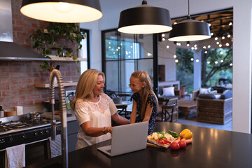 Senior caucasian woman spending time in the kitchen with her granddaughter