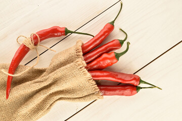 Red chili peppers, close-up, on a white wooden table.