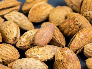 amandes non pelées sur fond noir, gros plan, pattern