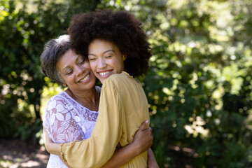 Fototapeta premium Senior mixed race woman and her daughter enjoying their time at a garden