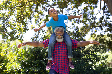 Portrait of a senior African American man  and his grandson enjoying their time at the garden