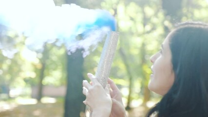 cheerful pregnant lady holds blue color smoke grenade as male baby gender revealing sign among sunny autumn forest on warm day closeup. Gender Party