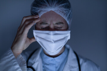 Healthcare worker with a headache wearing face mask during coronavirus Covid19 pandemic