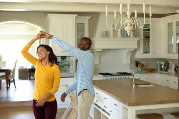 Happy couple dancing in their kitchen © WavebreakMediaMicro